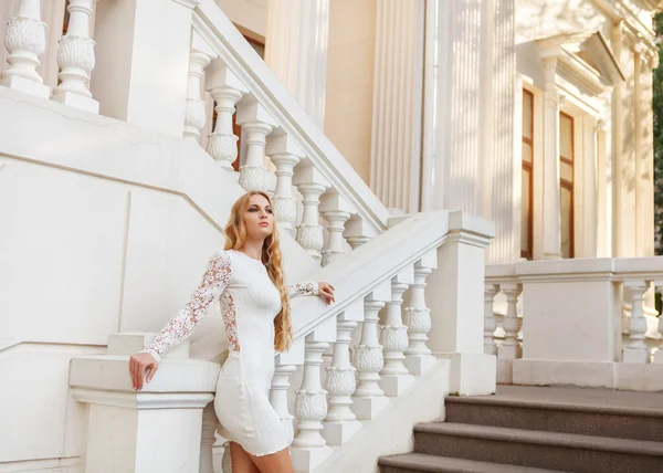 Mooie blonde vrouw in witte jurk buitenshuis — Stockfoto