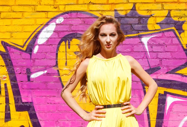 Ung attraktiv blond flicka nära väggen med graffiti — Stockfoto