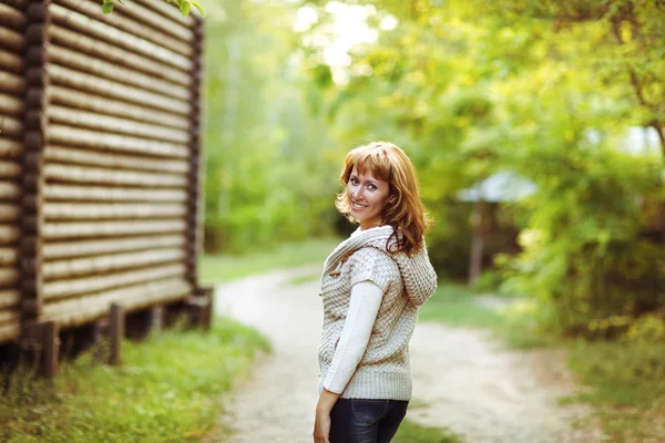Portrait of a smiling red haired woman in autumn day — Stock Photo, Image