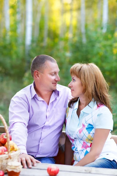 Feliz casal sorridente na floresta de outono no piquenique — Fotografia de Stock