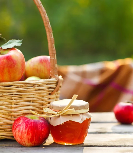 Apples in a basket on wooden table — Stock Photo, Image