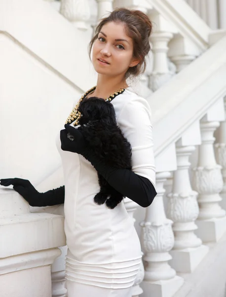 Young brunette woman hugging her lap dog puppy — Stock Photo, Image