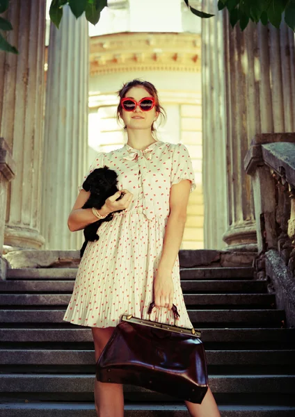 Jeune femme brune étreignant son chiot chiot à genoux — Photo