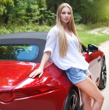 bir spor arabanın yakınında duran genç kadın