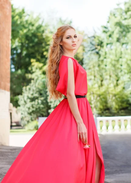 Blond woman in long red dress outdoors — Stock Photo, Image