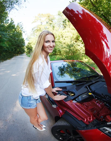 Kvinna som står nära öppnade huven på den trasiga cabrioleten — Stockfoto