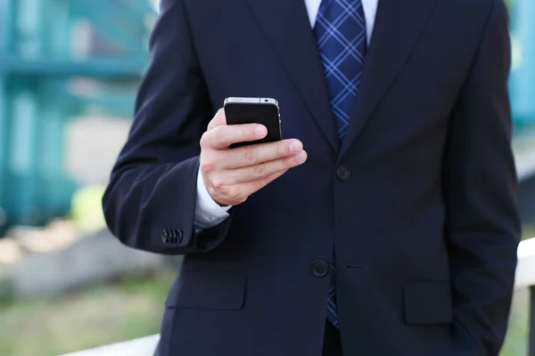 Närbild på händerna av affärsmannen med en mobiltelefon — Stockfoto