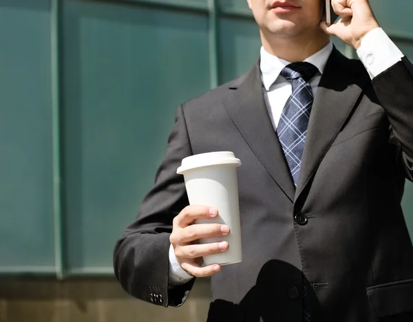 Close up of the hands of the businessman with a mobile phone and — Stock Photo, Image