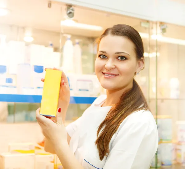 Portrait d'une jeune pharmacienne montrant une boîte à médicaments — Photo