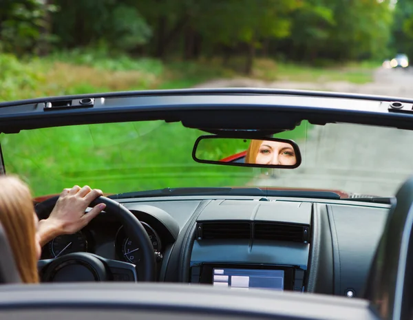 Mooie blonde jonge vrouw in een sportwagen — Stockfoto