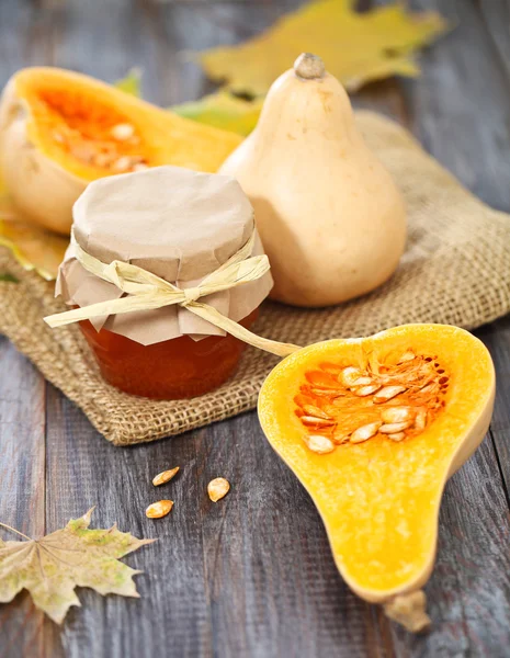 Pompoenen, jam, noten en mand met appelen — Stockfoto