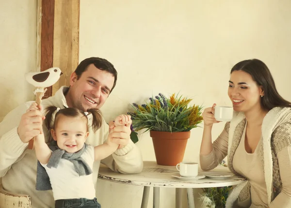 Família feliz com um ano de idade bebê menina beber café interior — Fotografia de Stock