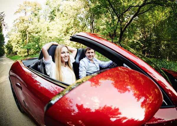 Casal em cabriolet vermelho em um dia ensolarado — Fotografia de Stock