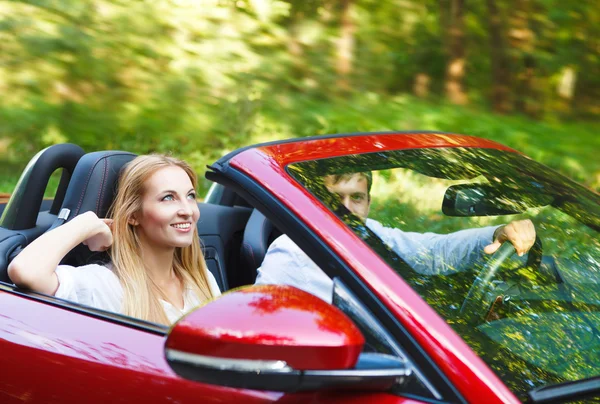 Couple in red cabriolet in a sunny day — Stock Photo, Image