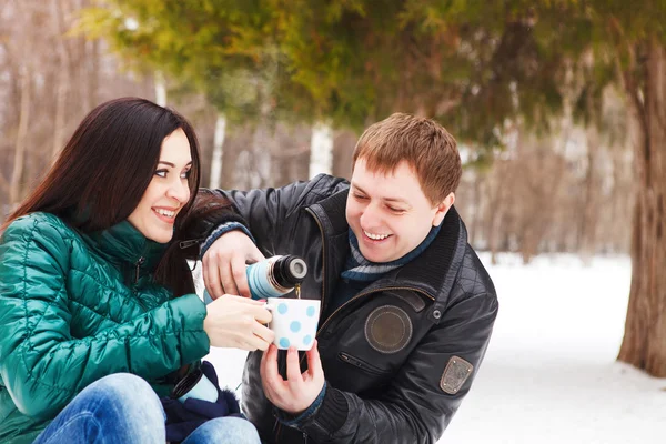 Feliz jovem casal se divertindo no parque de inverno — Fotografia de Stock