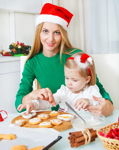 Adorable little girl with her mother baking Christmas cookies — Stock Photo, Image
