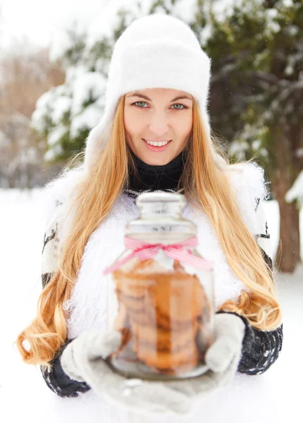Smiling woman holding cookies jar in her hands — Stock Photo, Image