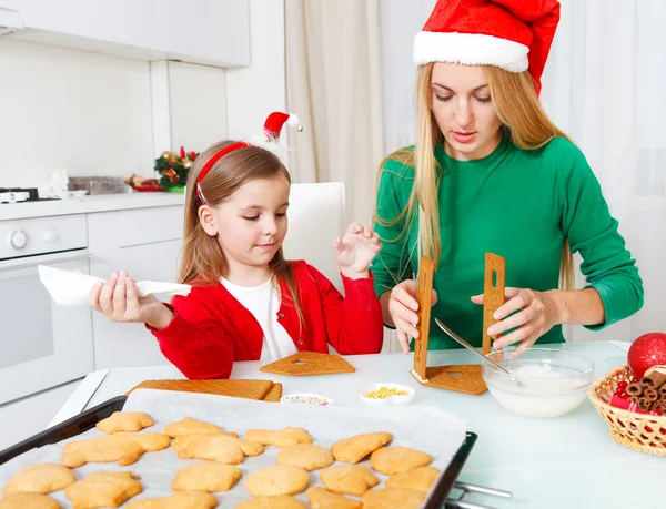 Petite fille avec sa mère cuisinant des biscuits de Noël — Photo