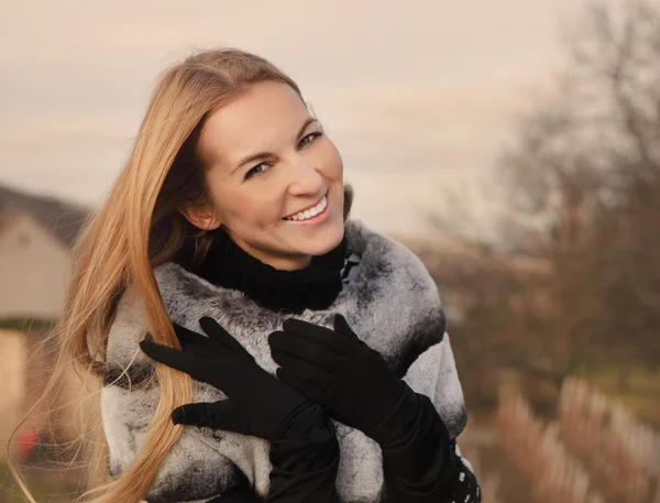 Portret uroda uśmiechający się blond kobietę noszenie futra coa — Zdjęcie stockowe
