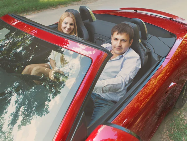 Jeune couple heureux près de la voiture rouge — Photo