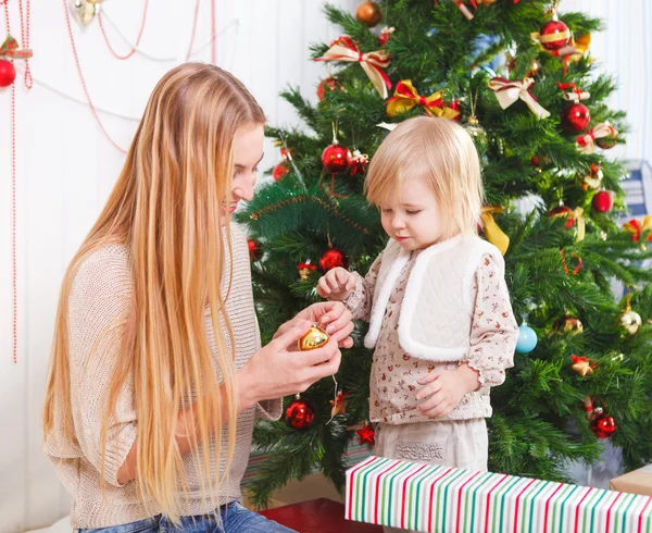 Matka se svou malou dcerou pod vánoční stromeček — Stock fotografie
