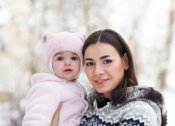 Jovem mãe morena com sua filha ao ar livre. Inverno — Fotografia de Stock