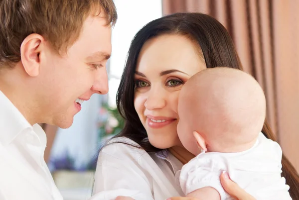 Glada leende familj med lilla flicka — Stockfoto