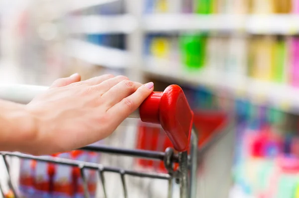 Female shopper with trolley at supermarket — Stock Photo, Image