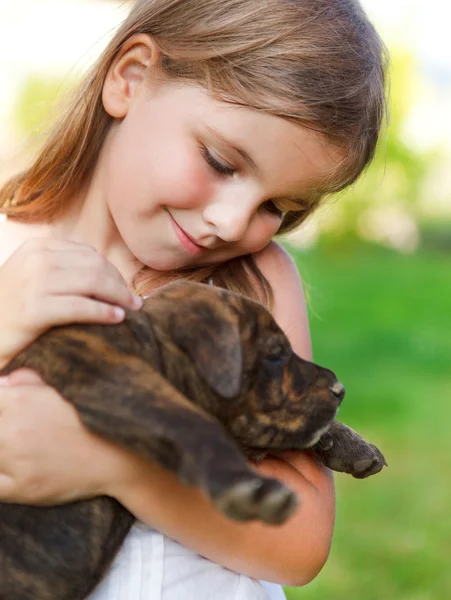 Schattig klein meisje knuffelen haar hond puppy. — Stockfoto