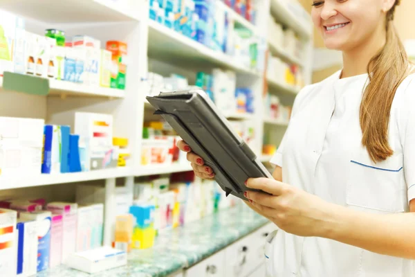 Farmacista che lavora con un tablet in farmacia — Foto Stock