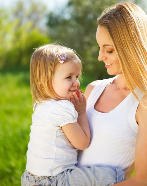 Glad mamma och hennes lilla dotter på våren — Stockfoto