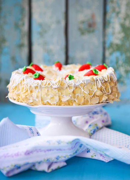 Pastel de zanahoria con hielo y pequeñas zanahorias sobre fondo de madera — Foto de Stock