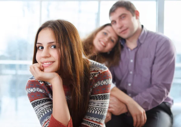 Adolescente souriante assise devant ses parents — Photo