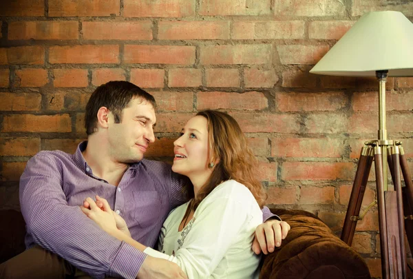 Pareja feliz sentada en el sofá — Foto de Stock