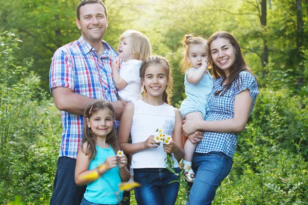 Jovem família feliz com quatro crianças ao ar livre — Fotografia de Stock