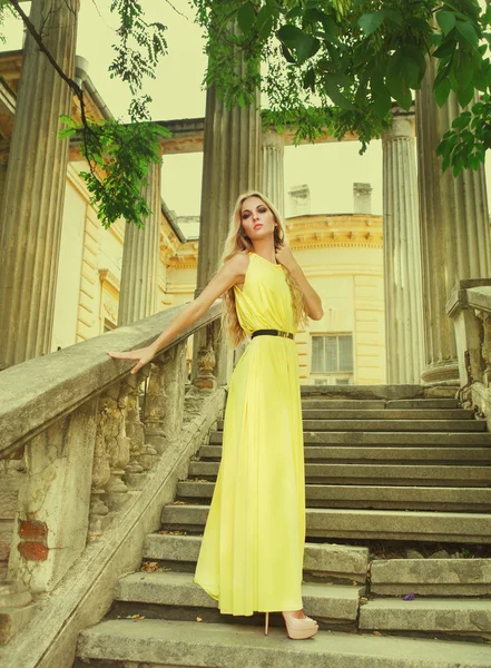 Belle femme blonde en robe longue jaune — Photo