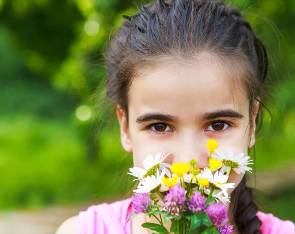 小小女孩微笑着与春天鲜花花束的肖像 — 图库照片