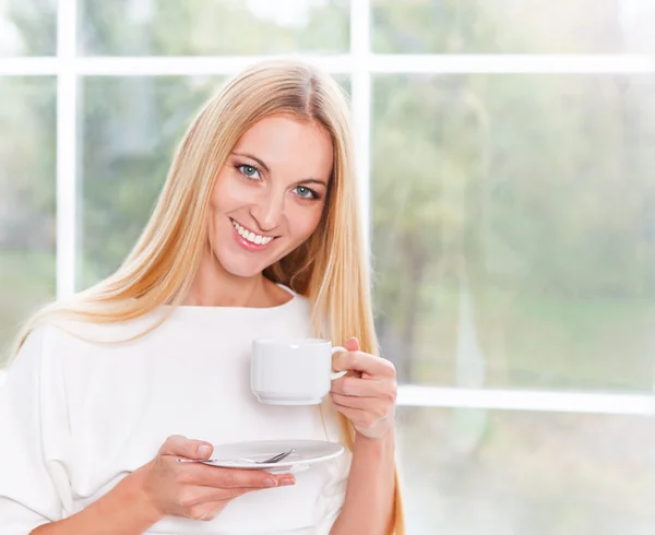 Retrato de una joven encantadora tomando una taza de té en casa —  Fotos de Stock