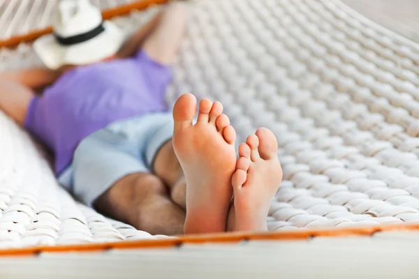 Mannen i hatten i en hängmatta en sommardag — Stockfoto