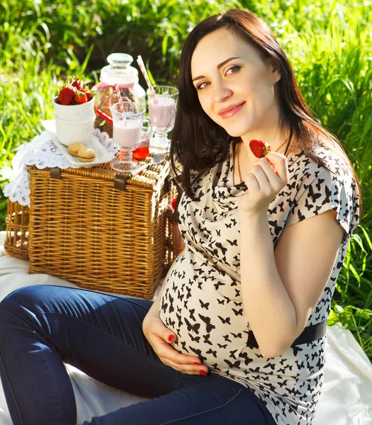 Mujer embarazada en el picnic en el parque de primavera — Foto de Stock