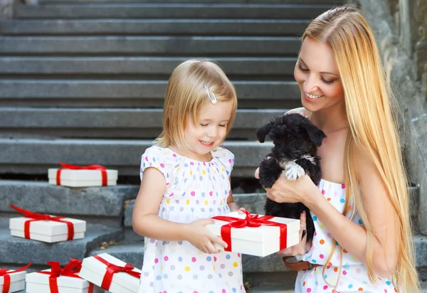 Sevimli küçük kız ve annesi sarılma yavru köpek — Stok fotoğraf