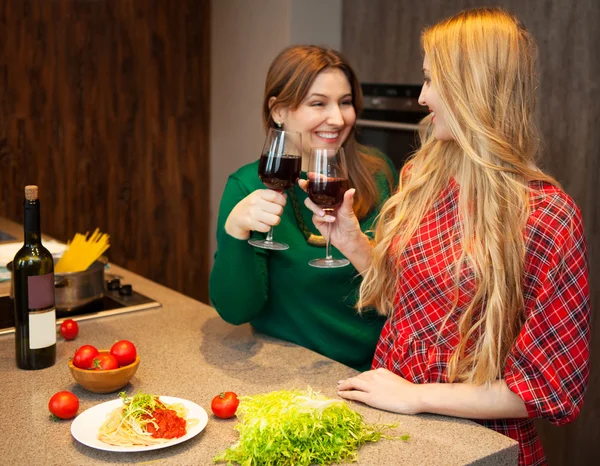 Zwei schöne junge Freundinnen, die zusammen Rotwein trinken — Stockfoto