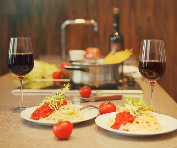 Espaguete com molho de tomate e vinho tinto em uma cozinha — Fotografia de Stock