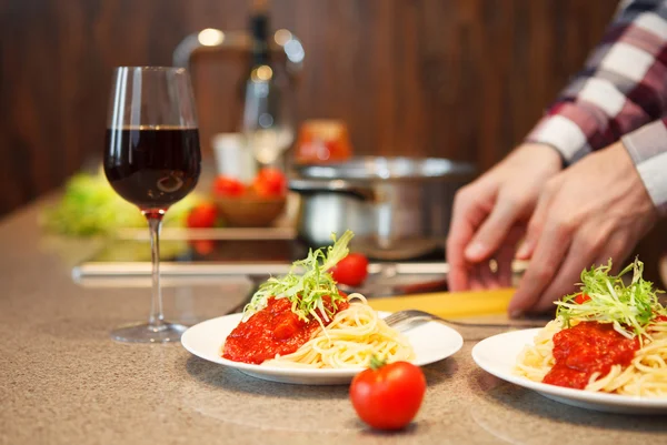 Stilig man matlagning hemma förbereda pasta i ett kök — Stockfoto
