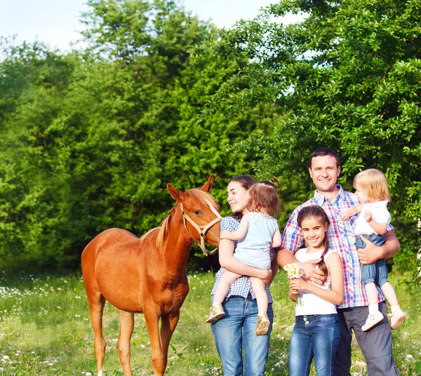 Glückliche junge Familie mit vier Kindern im Frühlingswald — Stockfoto