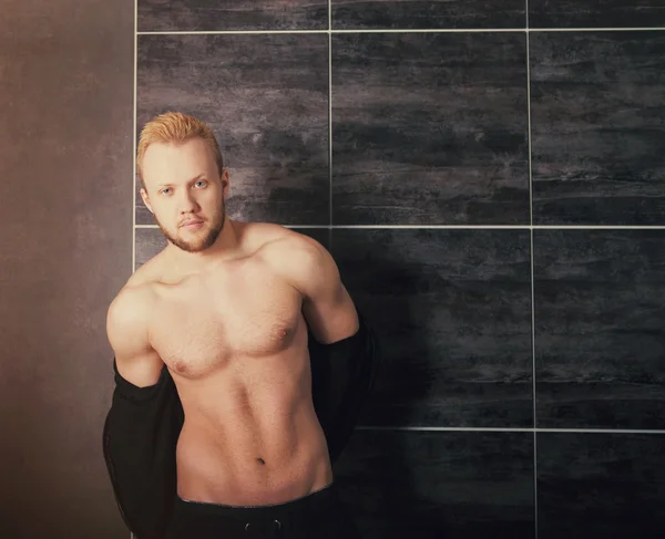 Przystojny mięśni model mężczyzna przy ścianie — Zdjęcie stockowe