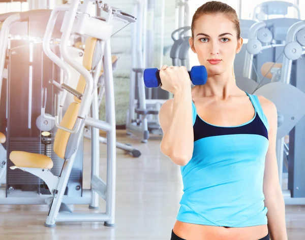 Sporty female doing physical exercise in gym — Stock Photo, Image