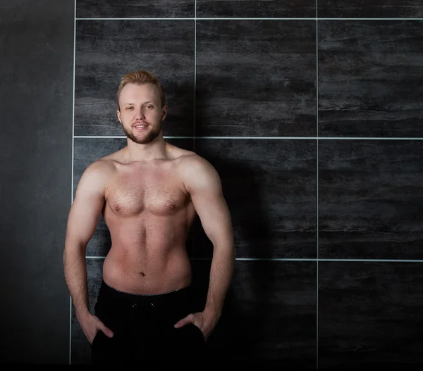 壁の近くのハンサムな筋肉男性モデル — ストック写真