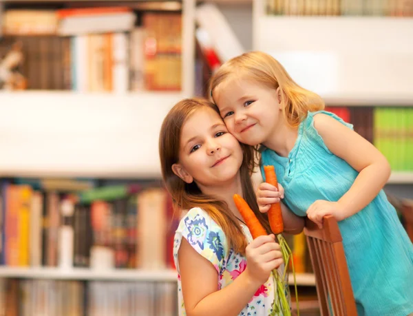 Kleine lachende meisjes met wortelen — Stockfoto