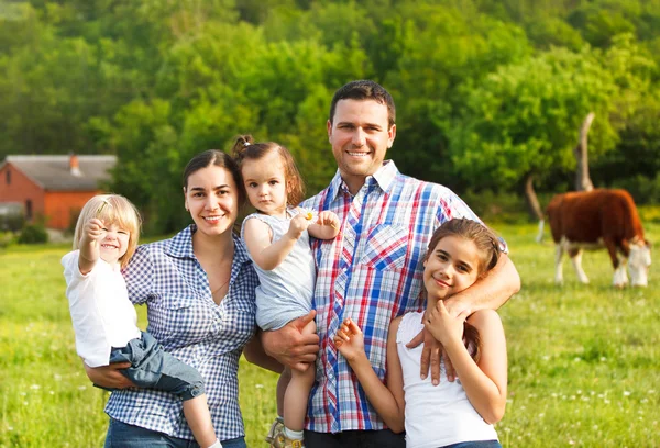 Jeune famille avec trois enfants à la ferme — Photo